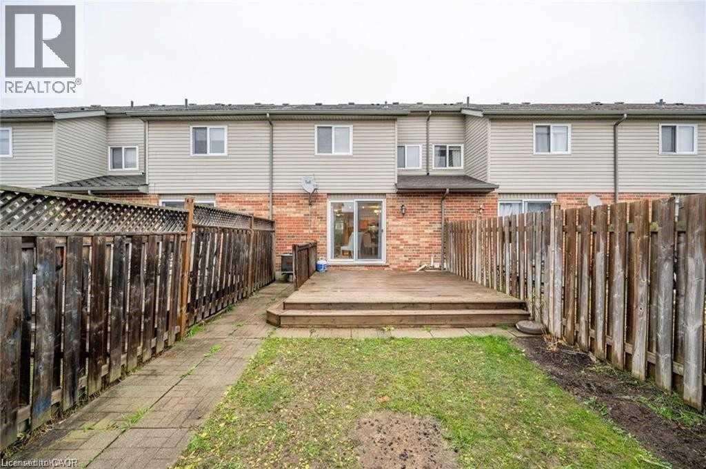 Rear exterior featuring a wooden deck with steps, a fenced yard, and a ground-level patio door - 27 Max Becker Drive, Kitchener, ON - Outdoor With Deck Patio Veranda With Exterior