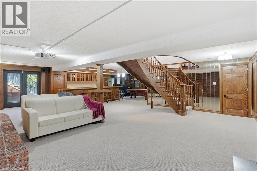 Lower level recreation space featuring a built-in wet bar, wood staircase, and exterior access - 176 Albion Falls Boulevard, Hamilton, ON - Indoor Photo Showing Other Room