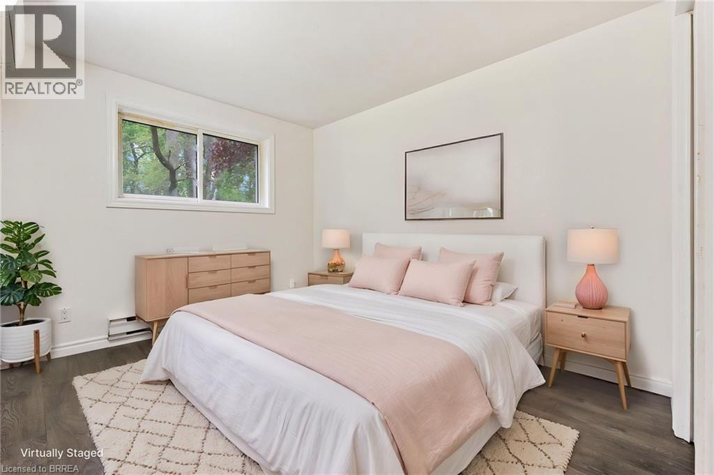 Bright room with a window providing natural light, white walls, and dark wood-finish flooring - 9 Cherry Street, Simcoe, ON - Indoor Photo Showing Bedroom