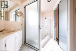 Bathroom featuring a white vanity with integrated sink, brass-finish faucet, and a large wall mirror -
