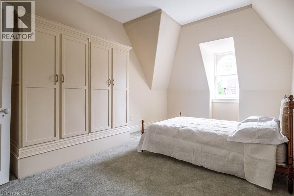 Attic room featuring a built-in wardrobe with panel doors and brass hardware - 370 Hess Street S, Hamilton, ON - Indoor Photo Showing Bedroom