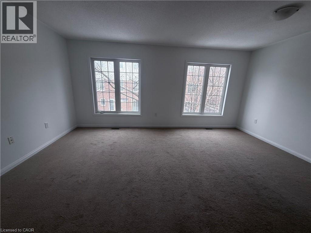 Spacious room featuring neutral carpeting and white painted walls - 50 Emick Drive, Ancaster, ON - Indoor Photo Showing Other Room