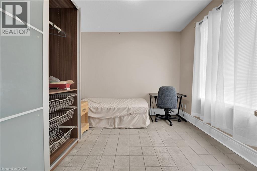 Neutral tone wall paint, tile flooring, and a large window with blinds - 738 King Street W, Hamilton, ON - Indoor