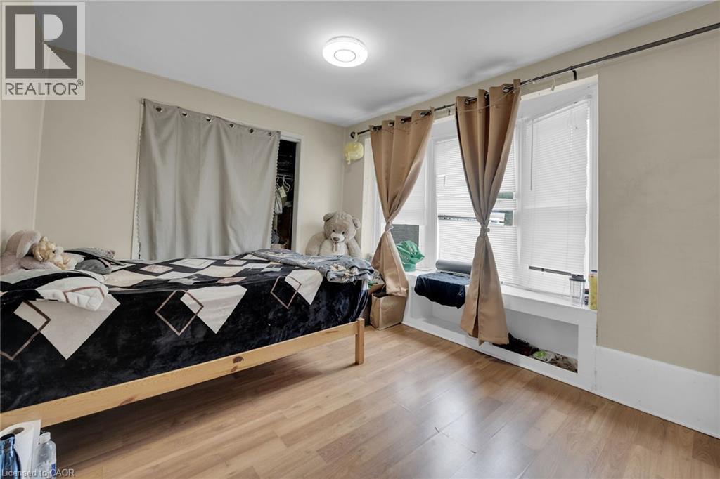 Room featuring wood-finish flooring, a contemporary flush-mount ceiling light, and neutral wall tones - 738 King Street W, Hamilton, ON - Indoor Photo Showing Bedroom
