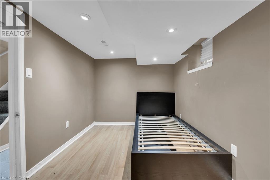 Room featuring light wood-finish flooring, recessed lighting, neutral wall tones, white baseboards, and a window with blinds - 738 King Street W, Hamilton, ON - Indoor Photo Showing Other Room