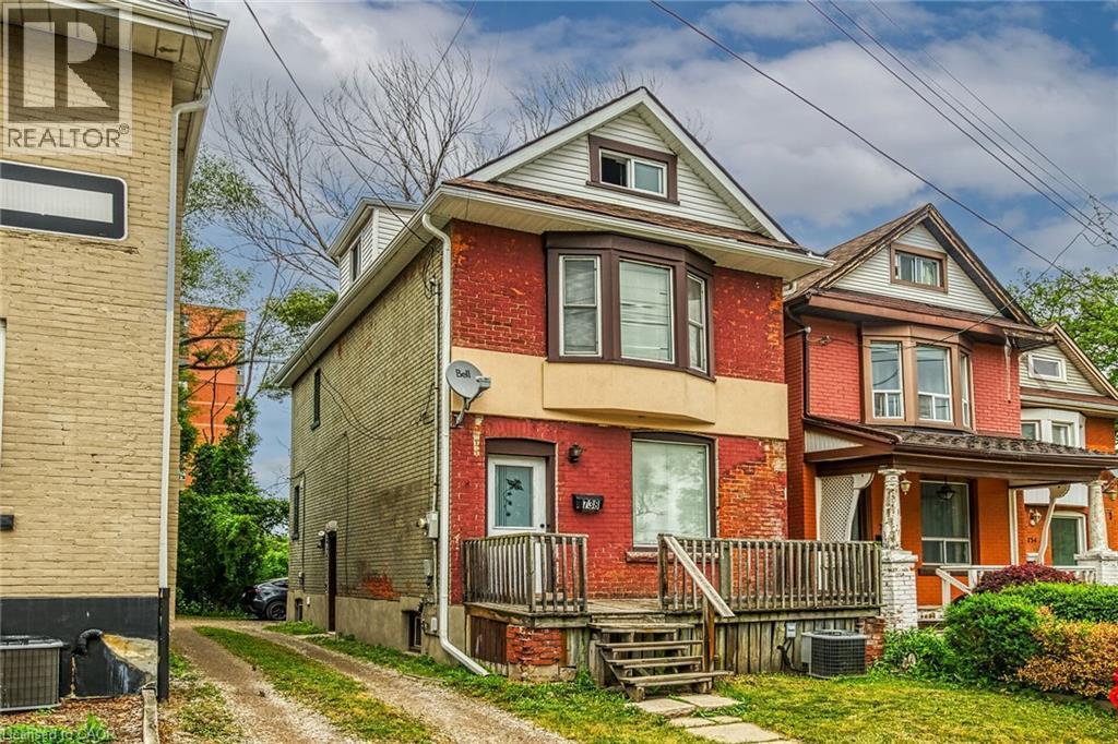 Brick exterior with bay window feature, dormer, and front porch - 738 King Street W, Hamilton, ON - Outdoor With Facade