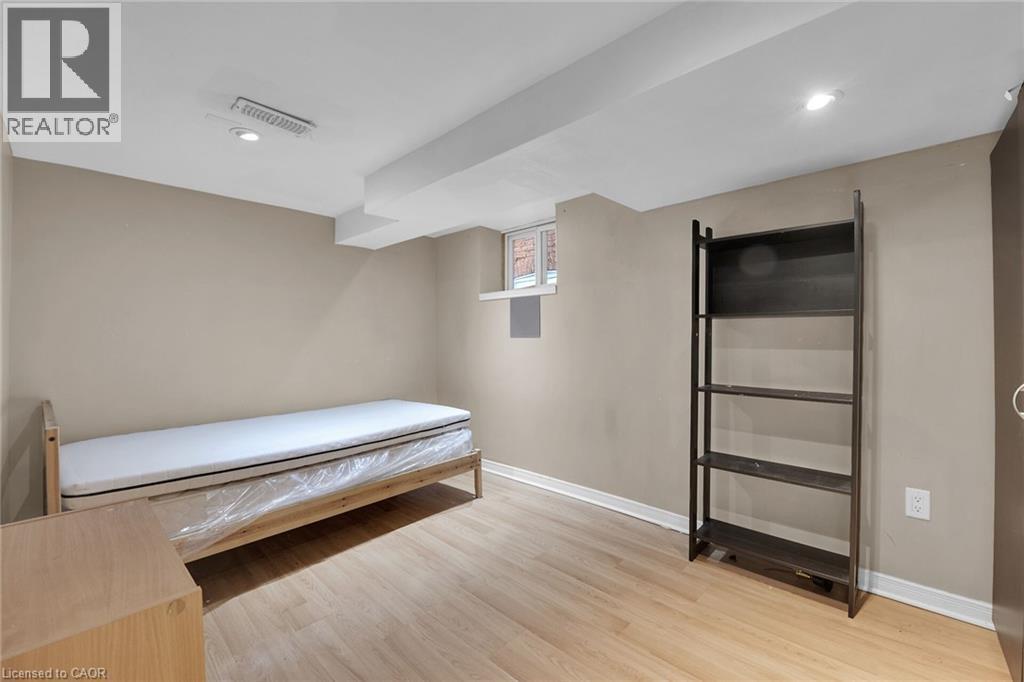 Recessed lighting illuminates this room featuring light wood-finish flooring, neutral wall tones, and an exposed ceiling beam - 738 King Street W, Hamilton, ON - Indoor Photo Showing Other Room