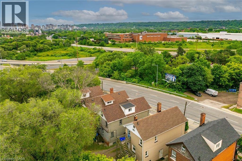 Residential streetscape featuring multiple properties with dormer windows and shingle roofs - 738 King Street W, Hamilton, ON - Outdoor With View