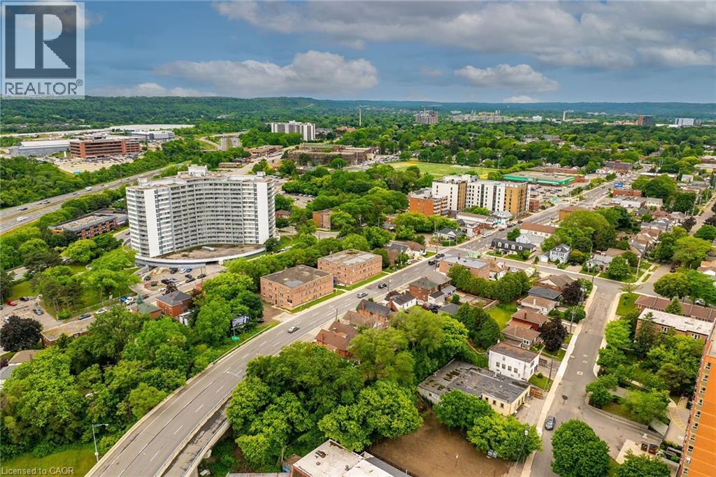Aerial perspective showcasing the surrounding urban landscape with extensive tree canopy, multi-lane roadways, and various architectural styles including high-rise residential buildings and lower-rise - 738 King Street W, Hamilton, ON - Outdoor With View
