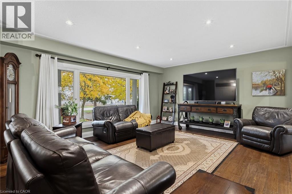 Spacious living area featuring wood-finish flooring, recessed lighting, a large window, and light green wall tones - 2116 Binbrook Road E, Hamilton, ON - Indoor Photo Showing Living Room