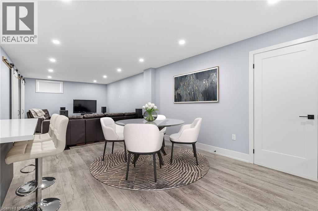 Spacious room featuring wood-finish flooring, recessed lighting, a built-in breakfast bar with a white countertop, and a modern interior door with black hardware - 2116 Binbrook Road E, Hamilton, ON - Indoor Photo Showing Dining Room
