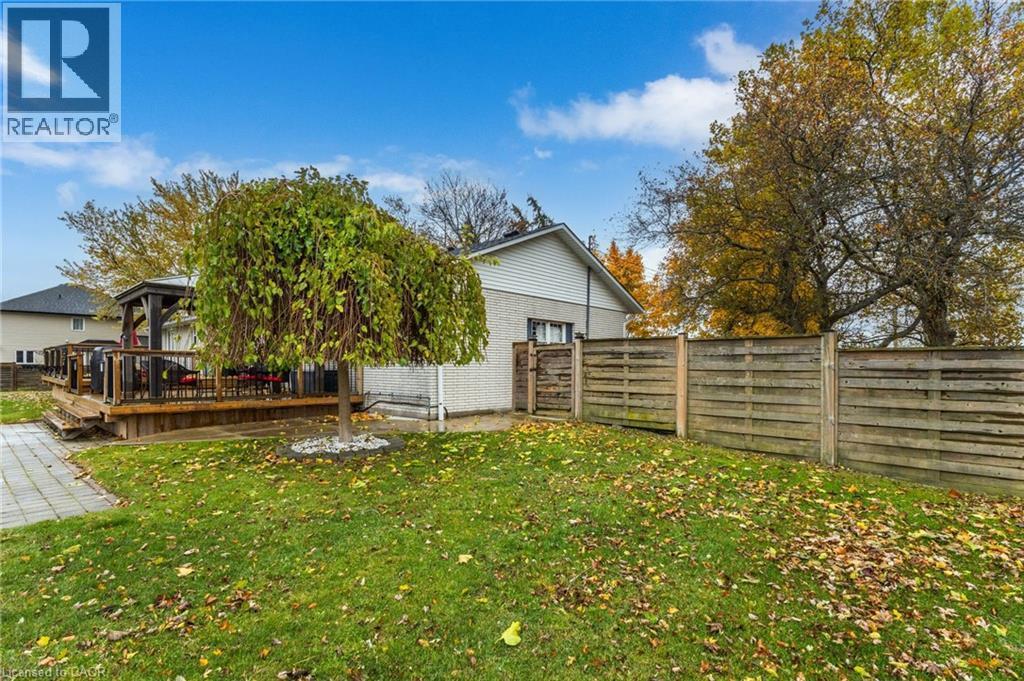 Expansive backyard featuring a wood deck with a built-in gazebo, a mature deciduous tree, a paved stone walkway, and a privacy fence - 2116 Binbrook Road E, Hamilton, ON - Outdoor