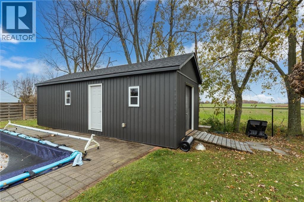 Standalone utility building featuring dark vertical siding and a shingled roof - 2116 Binbrook Road E, Hamilton, ON - Outdoor