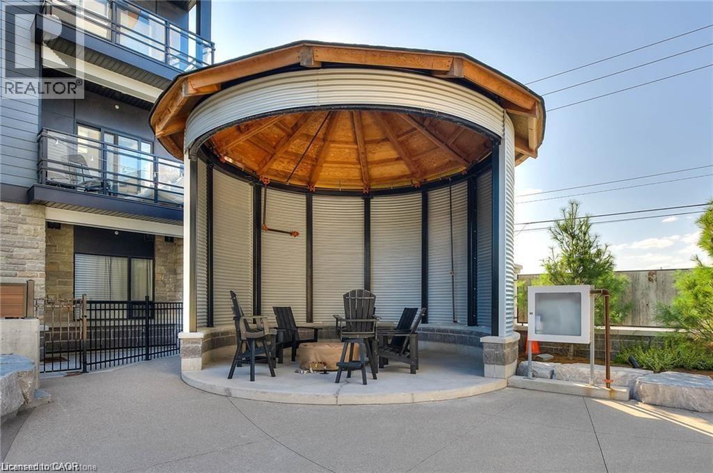 Outdoor circular gazebo featuring a wood-finish ceiling, corrugated metal siding, and a concrete base - 247 Northfield Drive E Unit# 207, Waterloo, ON - Outdoor With Balcony With Exterior