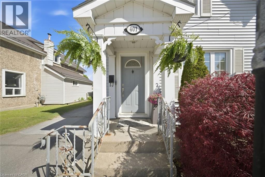 Front entrance featuring a light gray door with an arched window insert, flanked by white decorative columns - 401 West Street, Simcoe, ON - Outdoor