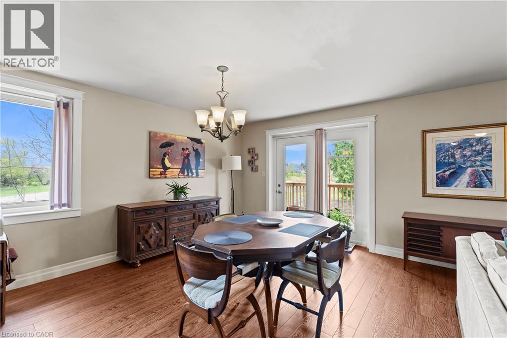 Dining area featuring wood-finish flooring, a contemporary chandelier, and French doors opening to an outdoor deck - 3 San Pedro Drive, Hamilton, ON - Indoor Photo Showing Dining Room