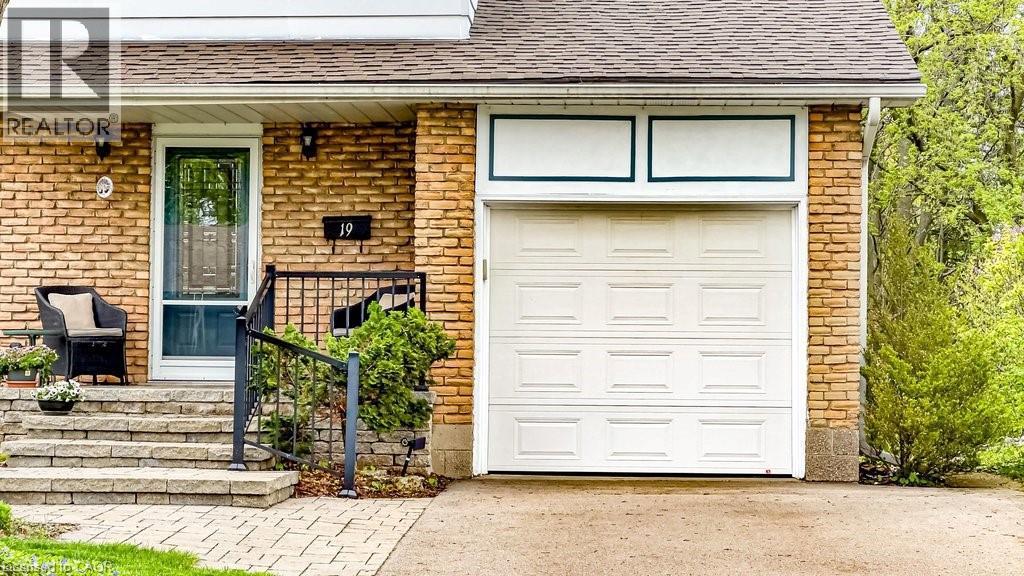 Brick facade residence featuring a single-car garage, stone paver steps, a storm door entry, and black metal handrailing - 19 Chateau Court, Hamilton, ON - Outdoor With Deck Patio Veranda With Exterior