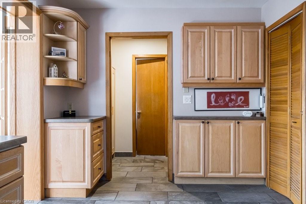 Light wood-finish cabinetry featuring curved open shelving, stone-finish countertops, and under-cabinet lighting - 19 Chateau Court, Hamilton, ON - Indoor Photo Showing Other Room