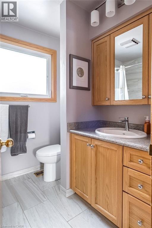 Bathroom with a light wood-finish vanity, integrated sink, and granite-look countertop - 19 Chateau Court, Hamilton, ON - Indoor Photo Showing Bathroom