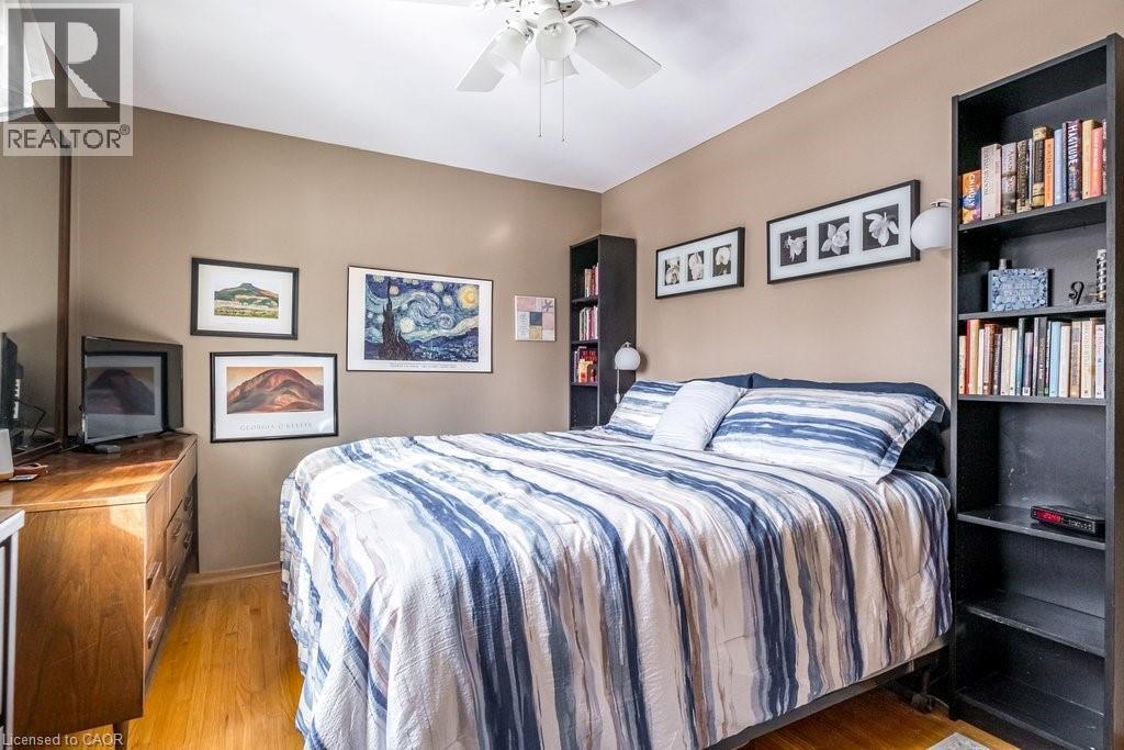 Warm-toned wall paint and hardwood flooring - 19 Chateau Court, Hamilton, ON - Indoor Photo Showing Bedroom