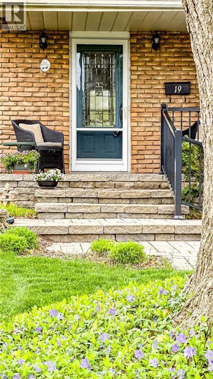 Brick facade with a contrasting dark green entry door and decorative screen door - 19 Chateau Court, Hamilton, ON - Outdoor With Deck Patio Veranda