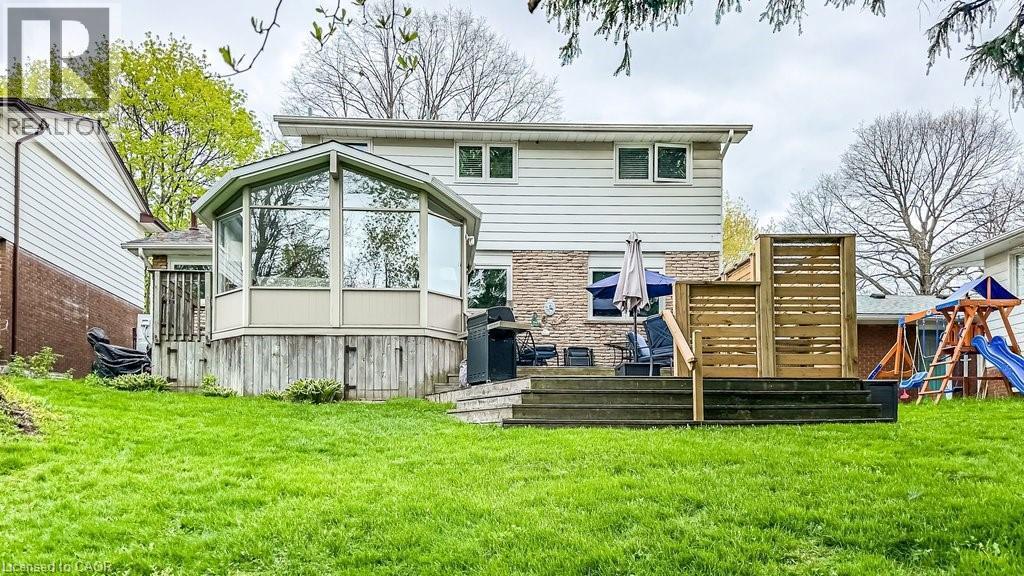 Expansive green lawn with a multi-level deck and an octagonal sunroom extension - 19 Chateau Court, Hamilton, ON - Outdoor