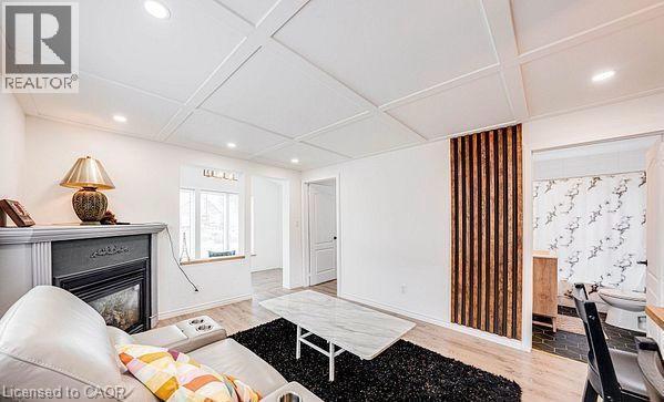 Spacious living area featuring a coffered ceiling with recessed lighting, a fireplace with a mantel, and wood-finish flooring - 43 Adair Avenue S, Hamilton, ON - Indoor With Fireplace