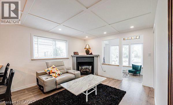 Living area featuring wood-finish flooring and a coffered ceiling - 43 Adair Avenue S, Hamilton, ON - Indoor With Fireplace