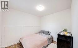 Panel accent wall with a flush mount ceiling light, wood-finish flooring, and white baseboards -