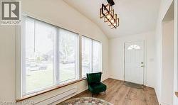 Entryway with vaulted ceiling, wood-finish flooring, and a modern geometric light fixture -