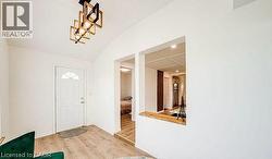 Entryway featuring a vaulted ceiling and wood-finish flooring -