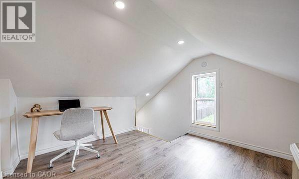 Attic space featuring sloped ceilings, recessed lighting, wood-finish flooring, a single window, and white trim - 43 Adair Avenue S, Hamilton, ON - Indoor Photo Showing Other Room
