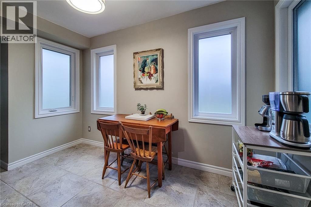 Room featuring light-toned walls, tile flooring, and multiple white-framed windows - 49 Ashwood Drive, Cambridge, ON - Indoor Photo Showing Dining Room