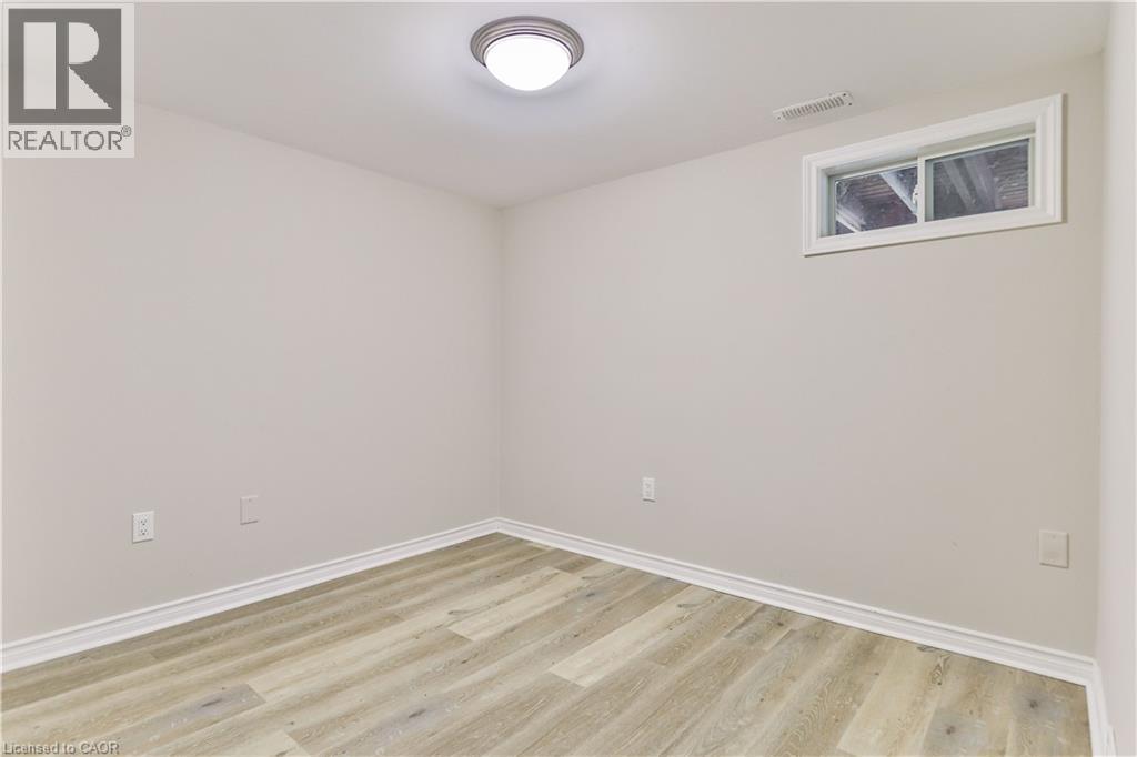 Light-toned wood-finish flooring complements neutral walls - 38 Dunkirk Drive Unit# B, Hamilton, ON - Indoor Photo Showing Other Room
