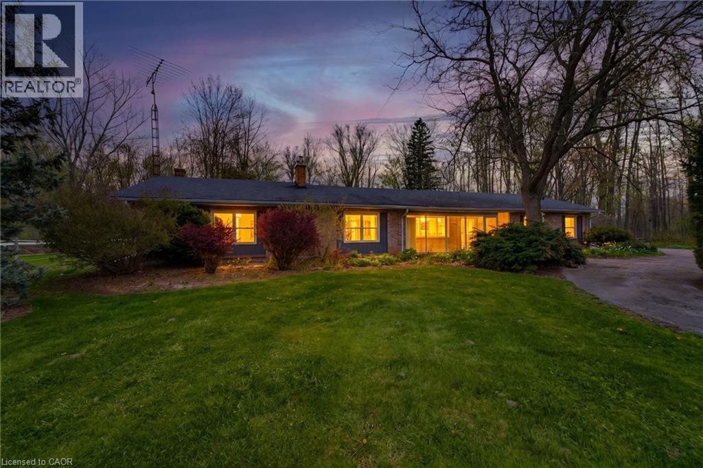 Ranch-style residence featuring a brick facade, dark roofing, and multiple prominent windows - 10 Huisman Lane, Hamilton, ON