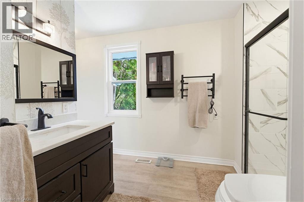 ensuite Bathroom featuring a dark wood vanity with white countertop, undermount sink, heated towel warmer & matte black faucet, - 10 Huisman Lane, Hamilton, ON