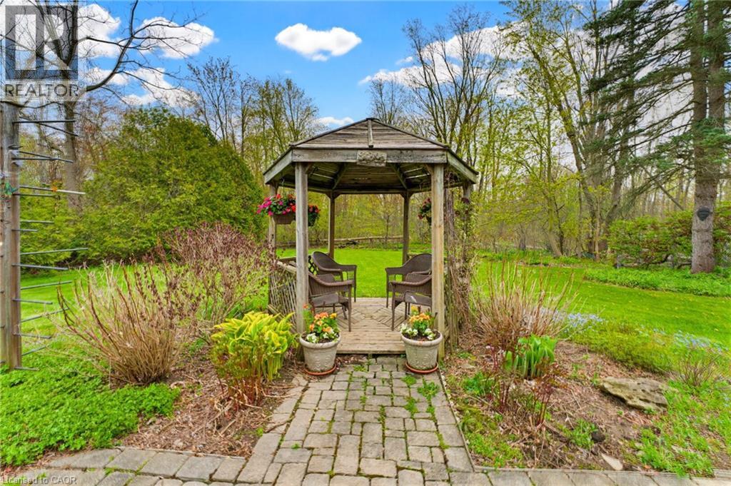 Wood gazebo with a slatted roof and a wood deck base, featuring a paver stone pathway - 10 Huisman Lane, Hamilton, ON