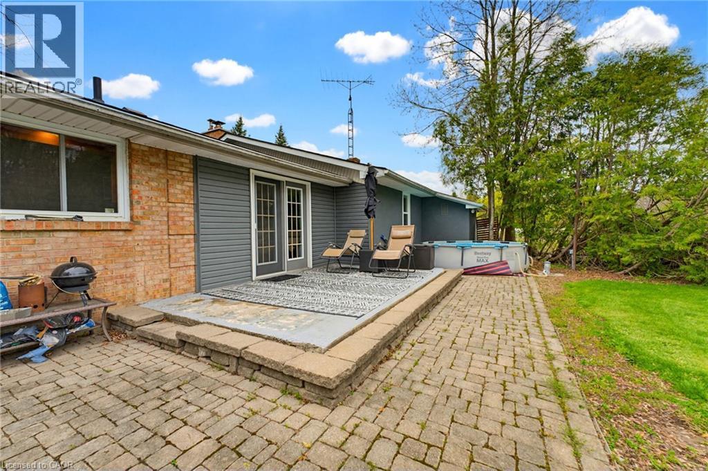 Rear exterior featuring a multi-level paver patio, brick and siding facade, and French doors - 10 Huisman Lane, Hamilton, ON