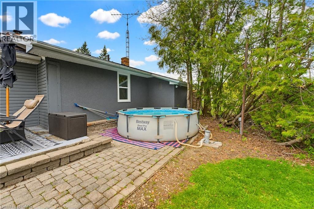 Hardscaped patio area featuring a stone block retaining wall and a paver pathway - 10 Huisman Lane, Hamilton, ON