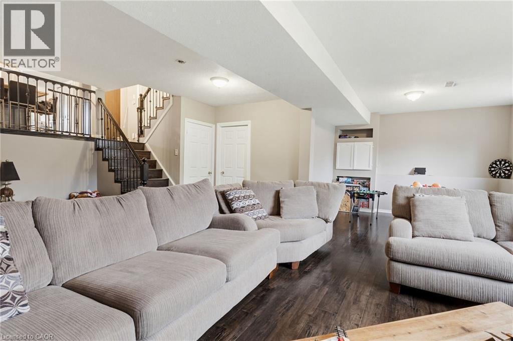 Finished basement space featuring dark wood-finish flooring, recessed lighting, and light-toned wall paint - 47 Hannah Crescent, Hamilton, ON - Indoor Photo Showing Living Room
