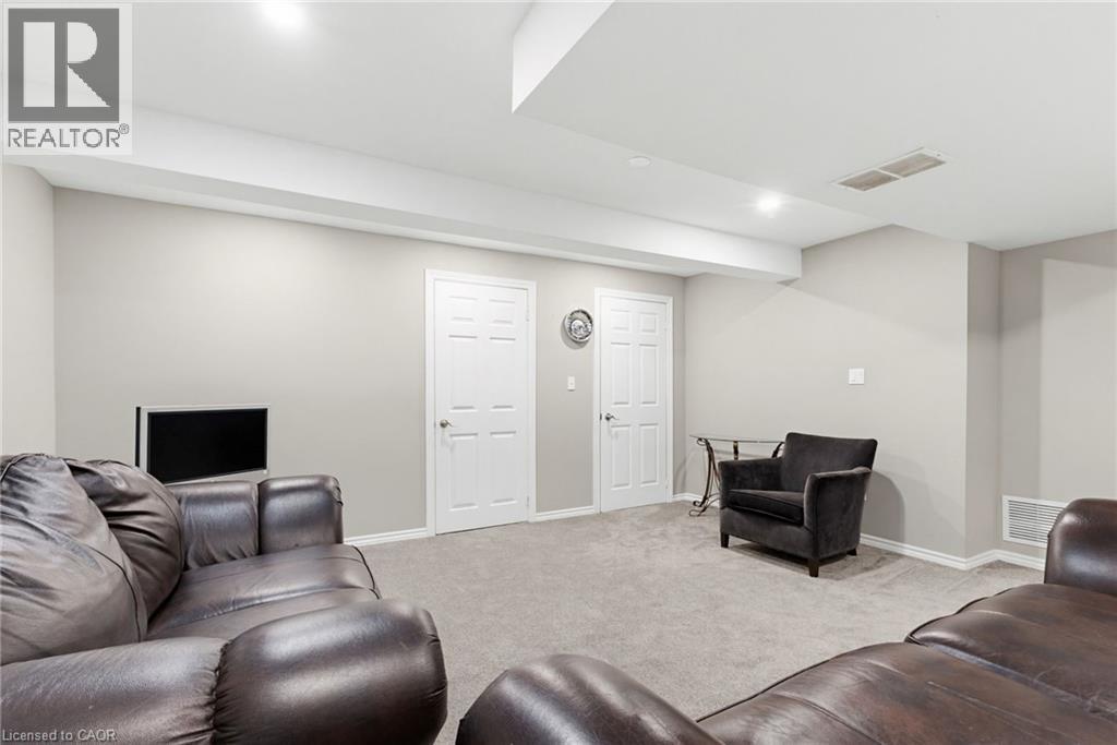 Carpeted recreational area with recessed lighting, two paneled doors, and light gray wall paint - 47 Hannah Crescent, Hamilton, ON - Indoor
