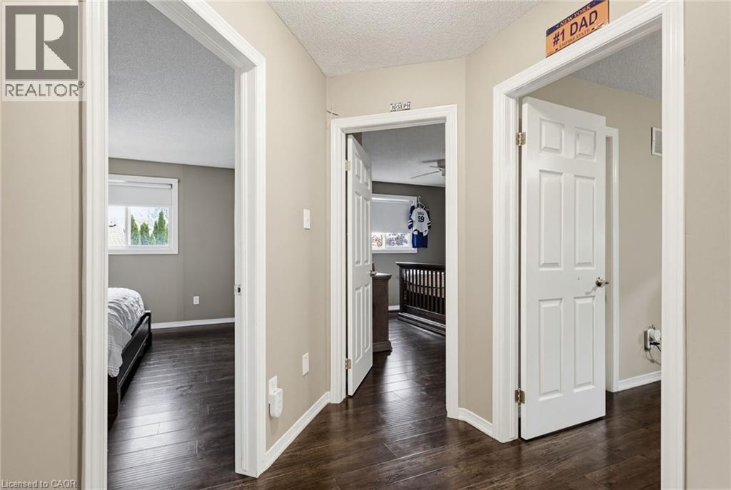 Hallway featuring dark wood-finish flooring, light neutral wall paint, and white trim - 47 Hannah Crescent, Hamilton, ON - Indoor Photo Showing Other Room