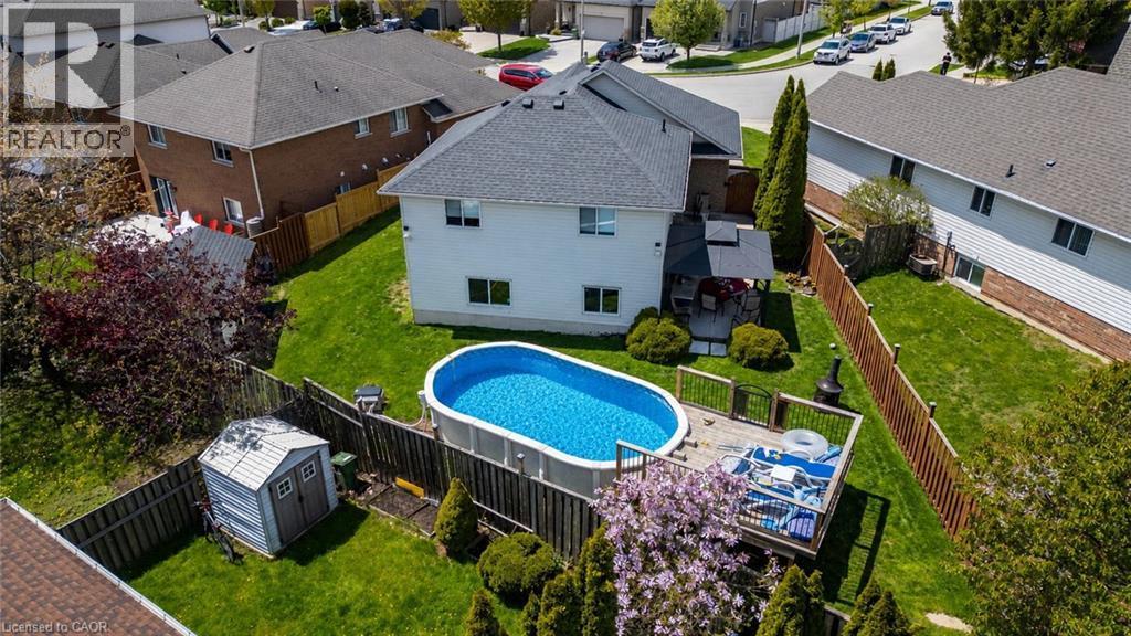 Expansive backyard featuring a large above-ground pool, a spacious wood deck, and a dedicated storage shed - 47 Hannah Crescent, Hamilton, ON - Outdoor With Above Ground Pool