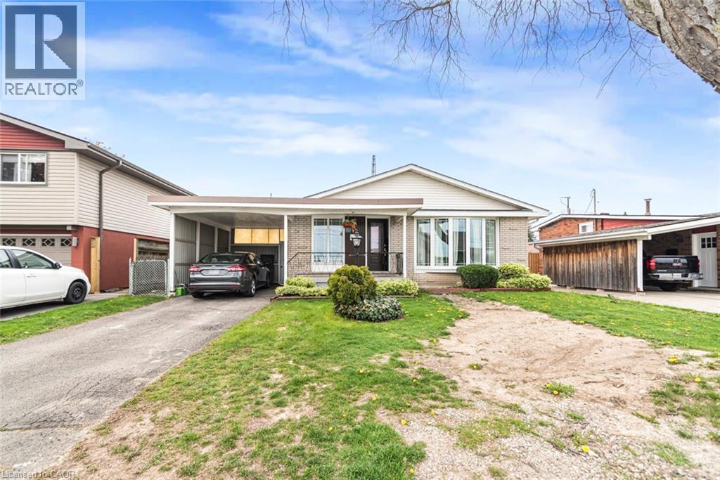 Brick exterior with a prominent bay window, featuring a covered carport and an additional detached carport - 112 Nash Road S, Hamilton, ON - Outdoor