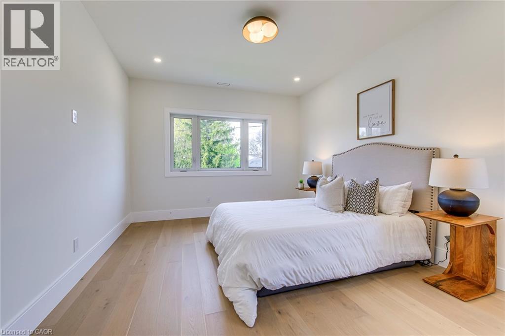Light wood-finish flooring complements white walls and trim - 1411 Mountain Grove Avenue, Burlington, ON - Indoor Photo Showing Bedroom