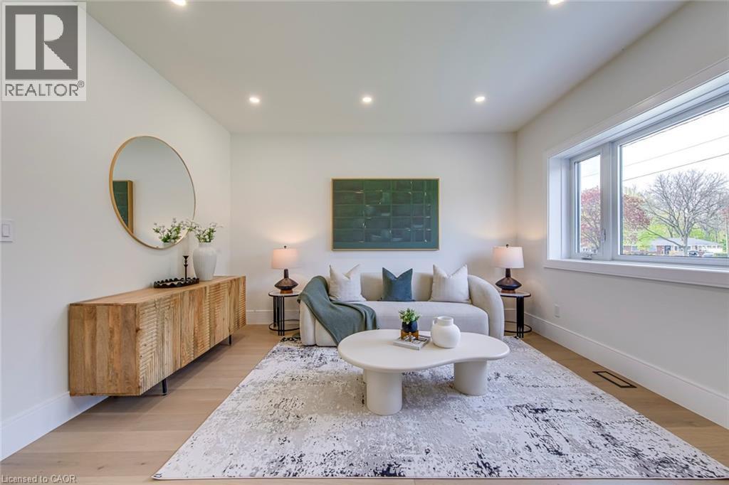 Bright living area featuring recessed lighting, wide plank wood-finish flooring, a large picture window, and white trim - 1411 Mountain Grove Avenue, Burlington, ON - Indoor Photo Showing Living Room