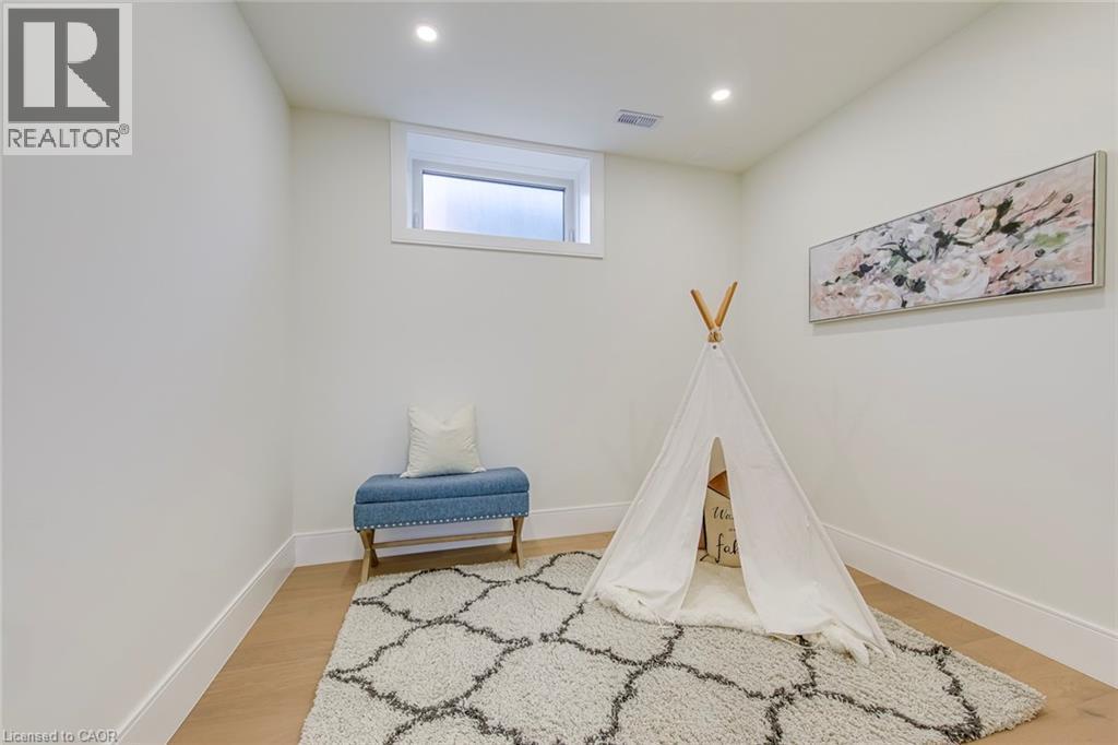 Bright room featuring a window, recessed lighting, and wood-finish flooring with white baseboards - 1411 Mountain Grove Avenue, Burlington, ON - Indoor