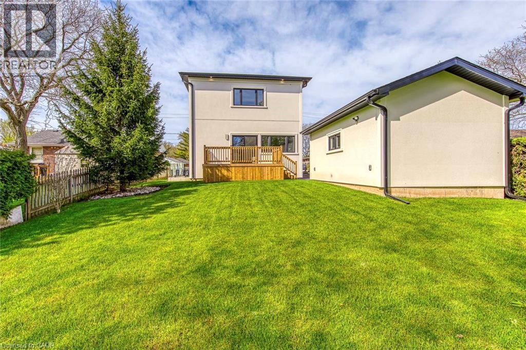 Expansive green lawn with a wooden fence and mature evergreen tree - 1411 Mountain Grove Avenue, Burlington, ON - Outdoor With Deck Patio Veranda