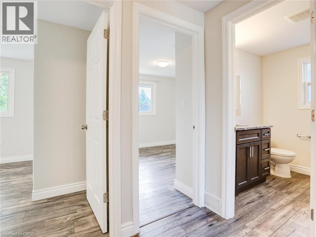 Hallway featuring wood-finish flooring, white trim, and light-colored walls - 833 Doon Village Road, Kitchener, ON - Indoor
