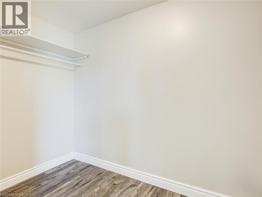 Storage closet featuring wood-finish flooring, white walls, and white baseboards - 833 Doon Village Road, Kitchener, ON - Indoor Photo Showing Other Room